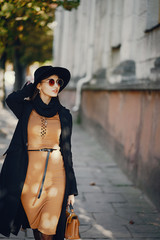 stylish girl walking through the city on a warm sunny autumn day