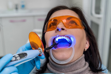 Woman in protective glasses sitting in dentist chair