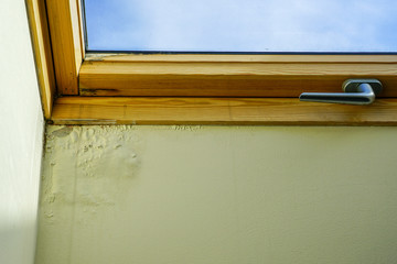 water and moisture damaged ceiling next to roof window