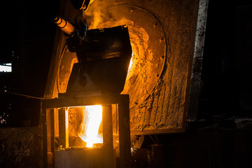 metal casting process with red high temperature fire in metal part factory