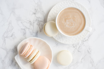 Fototapeta na wymiar Elegant sweet dessert macarons and cup of coffee on white marble table