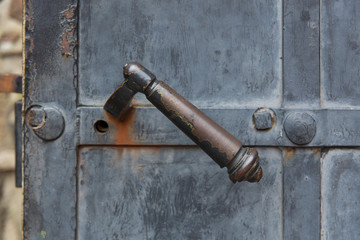 Old decorative door handle on metal door
