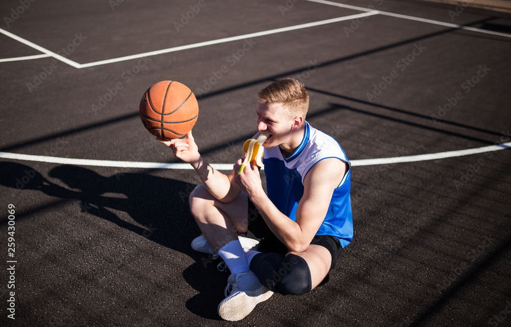 Wall mural basketball player eating banana