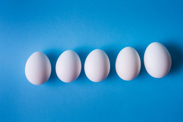 Eggs pattern over blue pastel background.