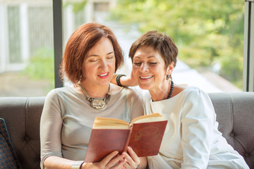 Portrait of senior women reading a book together