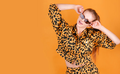 Charming blonde girl  in casual animal printed clothes in a colorful background.