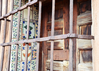 wooden window with tiles and wrought iron scrollwork