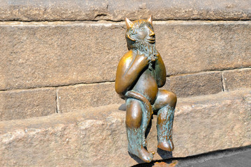 Lubeck. Bronze devil sitting on a stone banch outside St. Mary's Church or Marienkirche