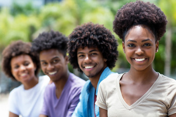 Laughing african american woman with group of young adults in line