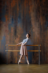 Young beautiful ballerina is posing in studio