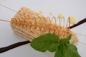 A slice of sweet classic layered cake of Napoleon on a light background