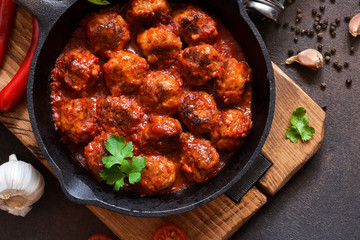 Meatballs in sweet and sour tomato sauce on the kitchen table. Top view
