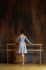 Young beautiful ballerina is posing in studio