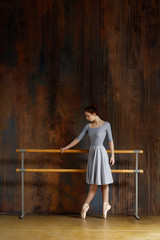 Young beautiful ballerina is posing in studio