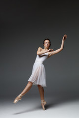 Naklejka premium Young beautiful ballerina is posing in studio
