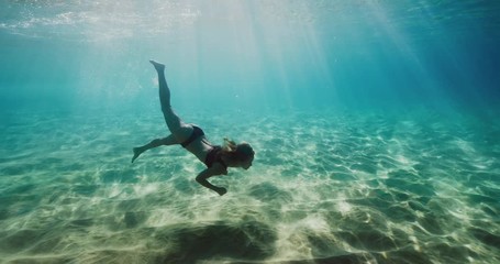 Beautiful woman swimming in underwater paradise