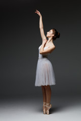 Young beautiful ballerina is posing in studio