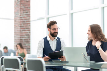 two employees discussing new ideas while sitting at the Desk