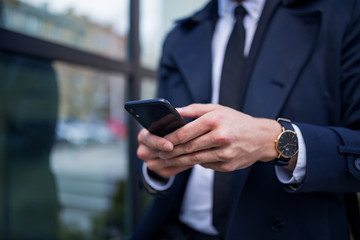 Close-up view of man hand holding modern black smartphone indoor