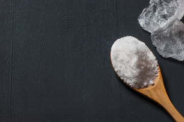 Naklejka premium Pure natural white crystal bath or rock salt with food or sea salt in wooden spoon on wooden background