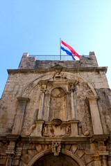 Historic town gate of town Korcula, on island Korcula, Croatia. Flag of Croatia on the top. 