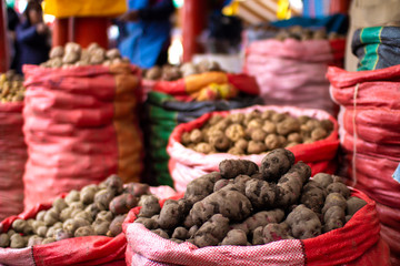 Different types and varieties of Peruvian organic potatoes in sacks at local market in Cusco, Peru. Natural healthy ingredient. - obrazy, fototapety, plakaty