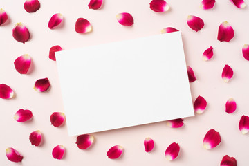 top view of red rose petal with white card
