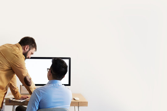 Coworking Process Businessman Desktop Connecting Networking Concept. Two confident young men looking at desktop monitor. Copy paste space mockup.