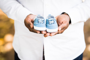 Small shoes in a fathers hands