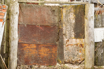 Old rusty door of abandoned storage, ugly gate of rusty metal