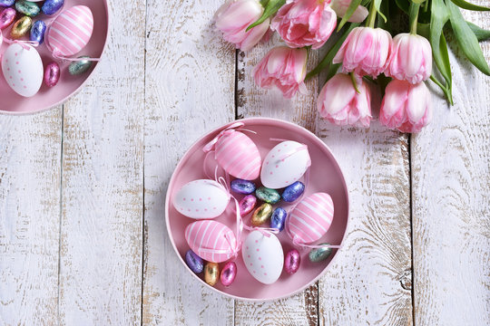 easter flat lay with painted eggs and pink tulips