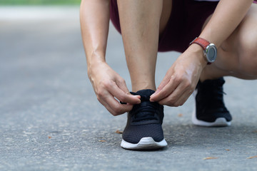 woman tying her shoes while running