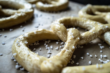 Raw pretzels with coarse salt are placed on a metal tray and are ready for baking in the oven. Traditional food. Oktoberfest.