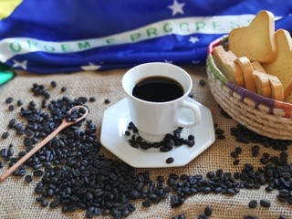 Cup of coffee with coffee beans strewn over jute and toast-4