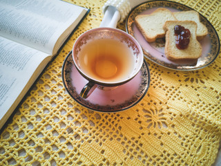 Cup of tea with toast and background with yellow crochet