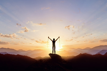 Silhouette of a tourist girl in the mountains against the background of the rising sun