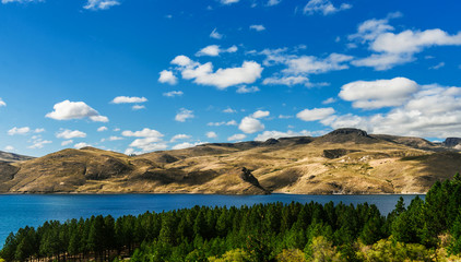 Beautiful landscape photo of turquoise aquamarine lake water and colorful yellow steppes in the mountains of Patagonia, Argentina