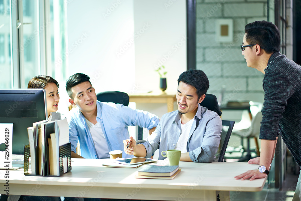 Wall mural four young asian entrepreneurs meeting in office