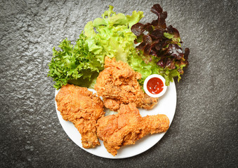 Fried chicken crispy kentucky on white plate with ketchup and salad lettuce vegetable on dark background