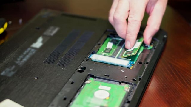 Man uninstalling memory. Laptop RAM upgrade