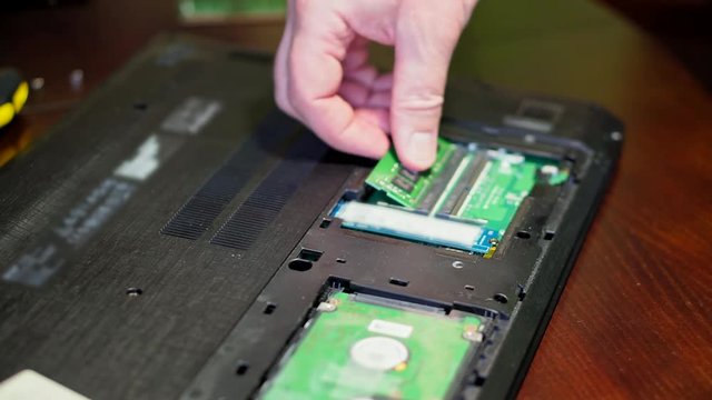Man uninstalling memory. Laptop RAM upgrade
