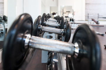 Fototapeta premium Multiple iron dumbbells in sport center