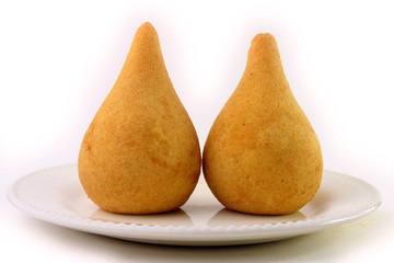 Coxinha in the dish, traditional snacks of Brazilian cuisine stuffed with chicken, isolated on white background