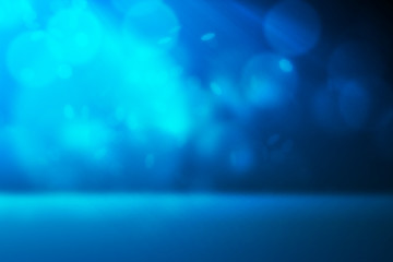 Blue light and bokeh falling from side with spot light on dark background