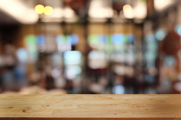 Empty dark wooden table in front of abstract blurred bokeh background of restaurant . can be used for display or montage your products.Mock up for space.