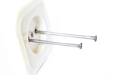 Concept accident prevention - to shove metal nails in the hole of electrical outlet on white background. Isolated. Side view