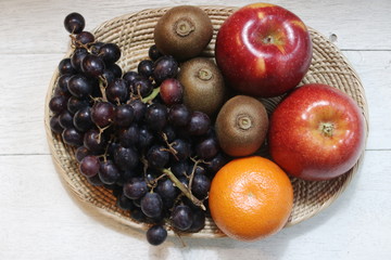 Grapes, Kiwi Fruit,Red Apple and Orange in Wood Basket