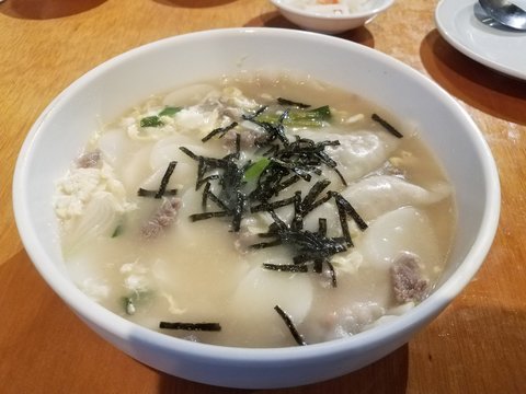 Korean Soup With Dumplings And Seaweed On Table