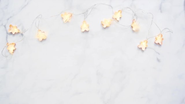 Flat lay. Christmas lights in shape of copper cookie cutters.