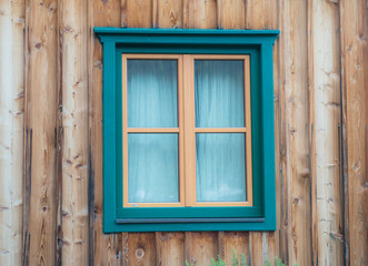 Green window in the wooden wall